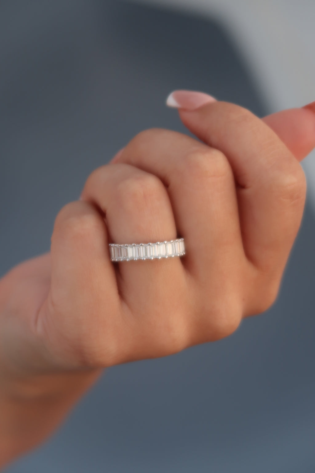 Hand wearing baguette cut moissanite eternity band showcasing brilliant linear sparkle and elegant profile