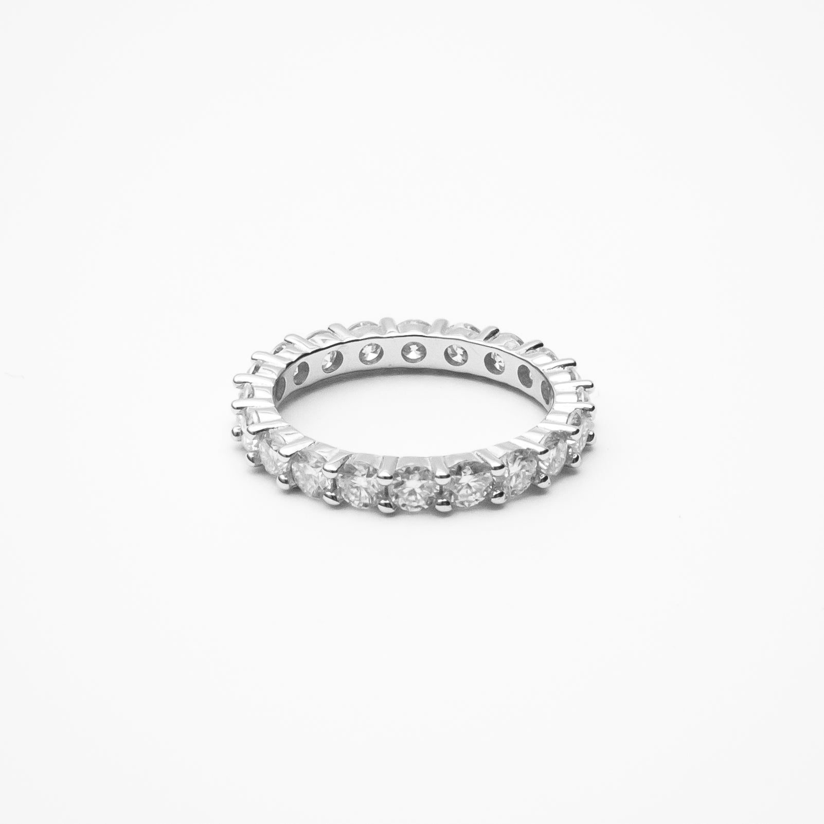 Round cut moissanite eternity band with continuous prong setting in white gold on clean white background showcasing full circle of brilliant stones