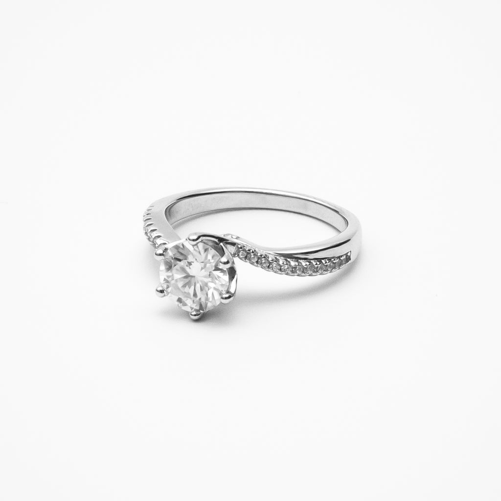 Round cut moissanite engagement ring with twisted pavé band in white gold setting on clean white background showcasing brilliant center stone