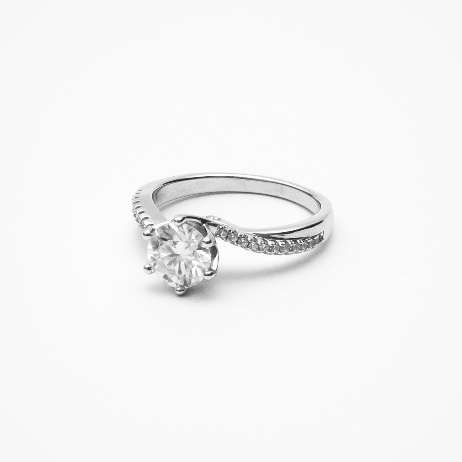 Round cut moissanite engagement ring with twisted pavé band in white gold setting on clean white background showcasing brilliant center stone