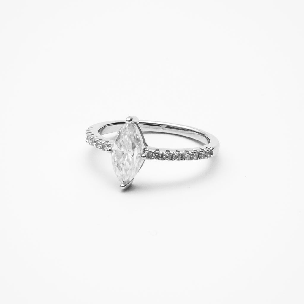 Marquise cut moissanite engagement ring with pavé band in white gold setting on clean white background showcasing elongated diamond shape
