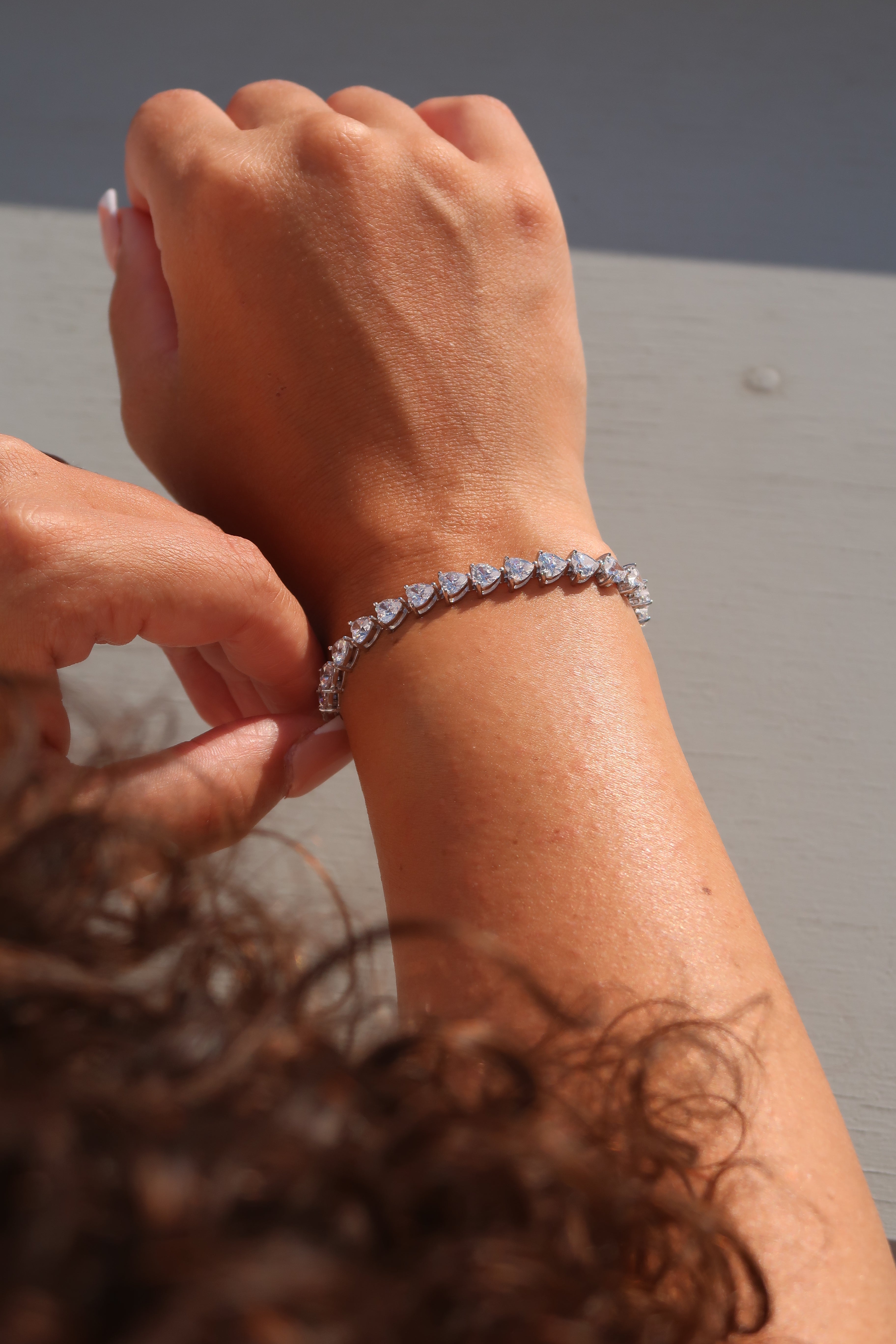 Heart cut moissanite tennis bracelet worn outdoors showcasing secure fit and brilliant fire