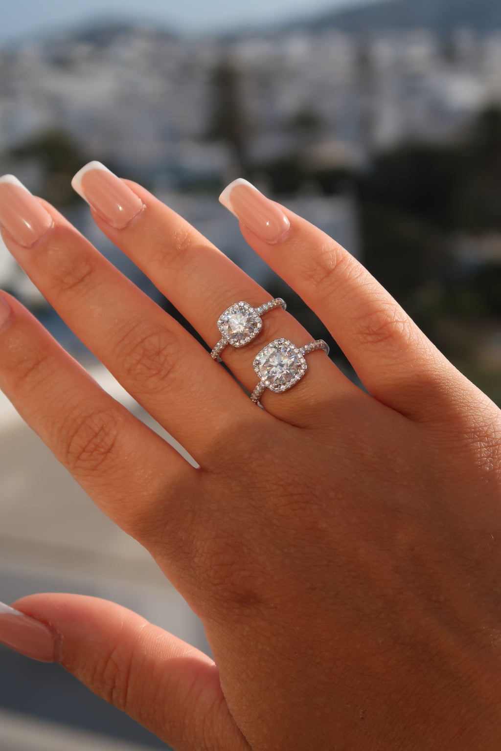 Hand with cushion cut moissanite halo engagement ring showing elegant profile and finger placement