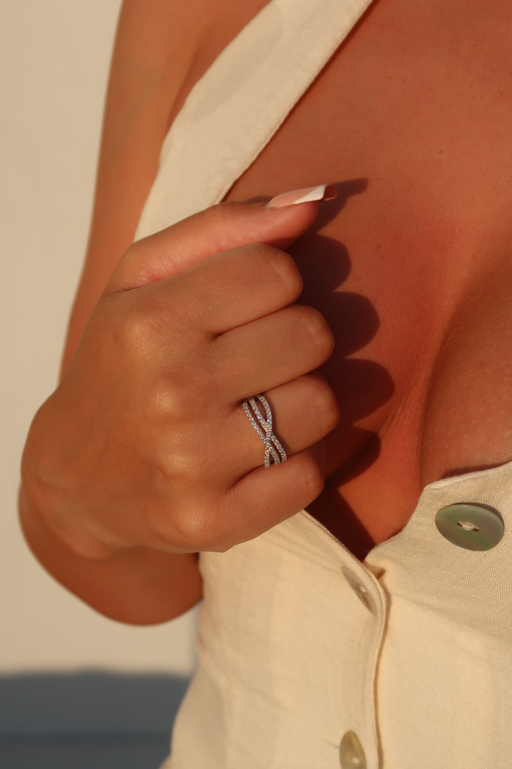 Close-up of hand wearing crossover pavé moissanite band demonstrating comfortable fit and elegant profile