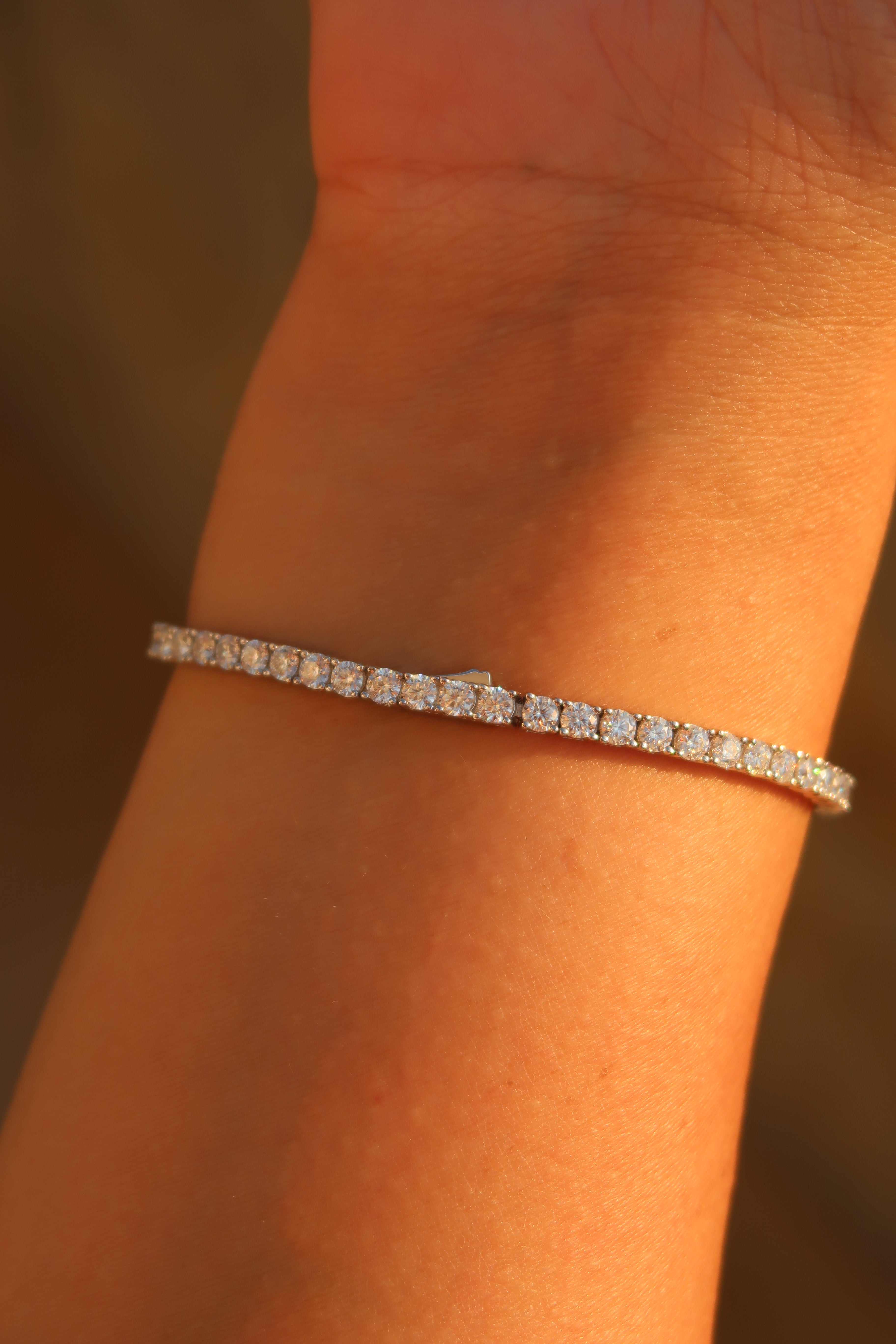 Close-up of moissanite tennis bracelet on wrist showing continuous line of round stones