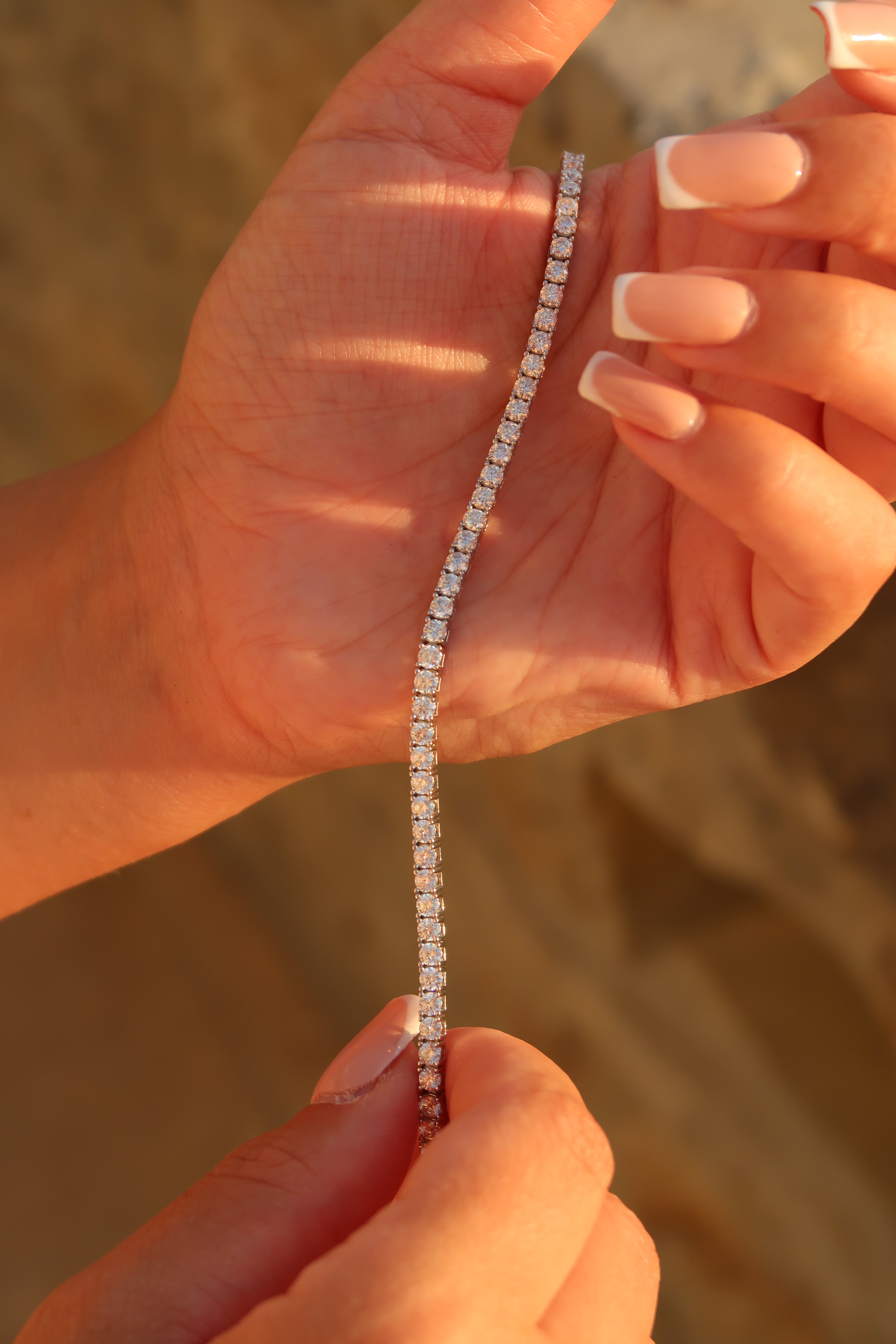 Hand adjusting moissanite tennis bracelet demonstrating comfortable fit and flexibility