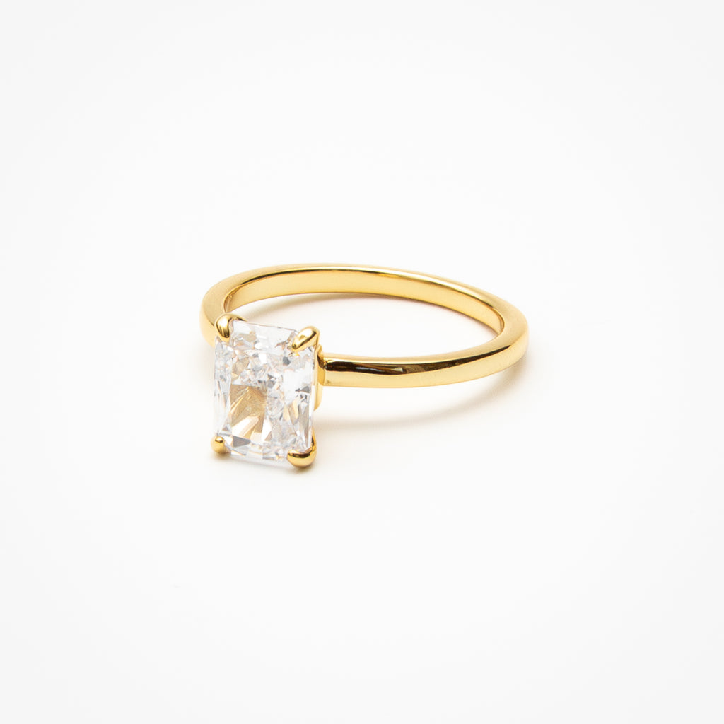 Radiant cut cubic zirconia solitaire engagement ring in yellow gold setting on clean white background showcasing step cut faceting and low profile design