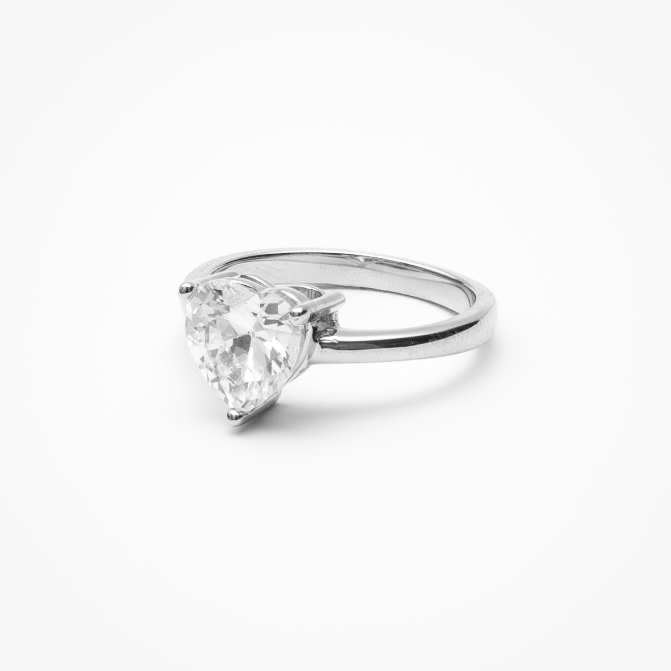 Heart cut cubic zirconia solitaire engagement ring in white gold setting on clean white background showcasing romantic heart shape and low profile design