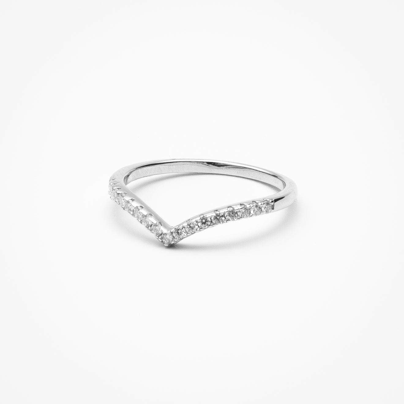 Curved pavé moissanite wedding band in white gold setting on clean white background showcasing V-shaped contour design for stacking with engagement rings