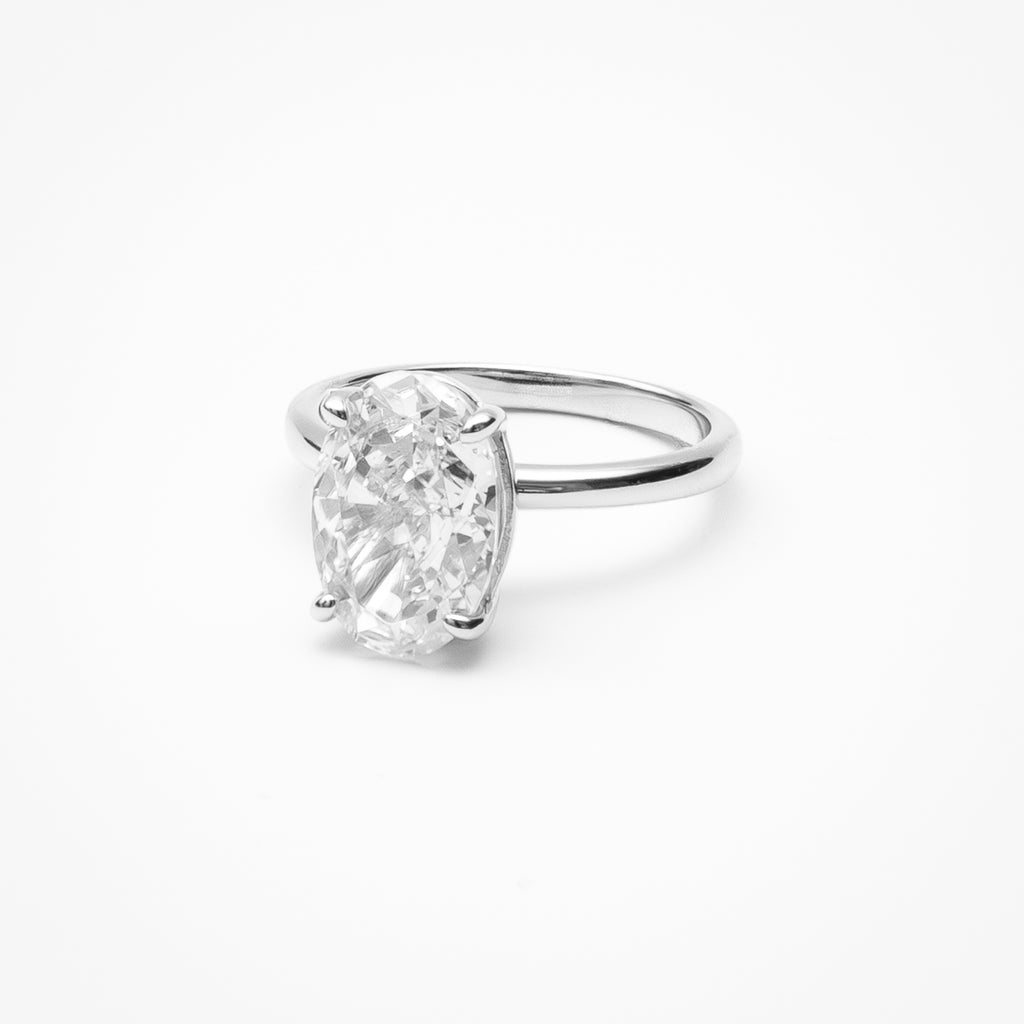 Oval cut cubic zirconia solitaire engagement ring in white gold setting on clean white background showcasing low profile design and classic elegance