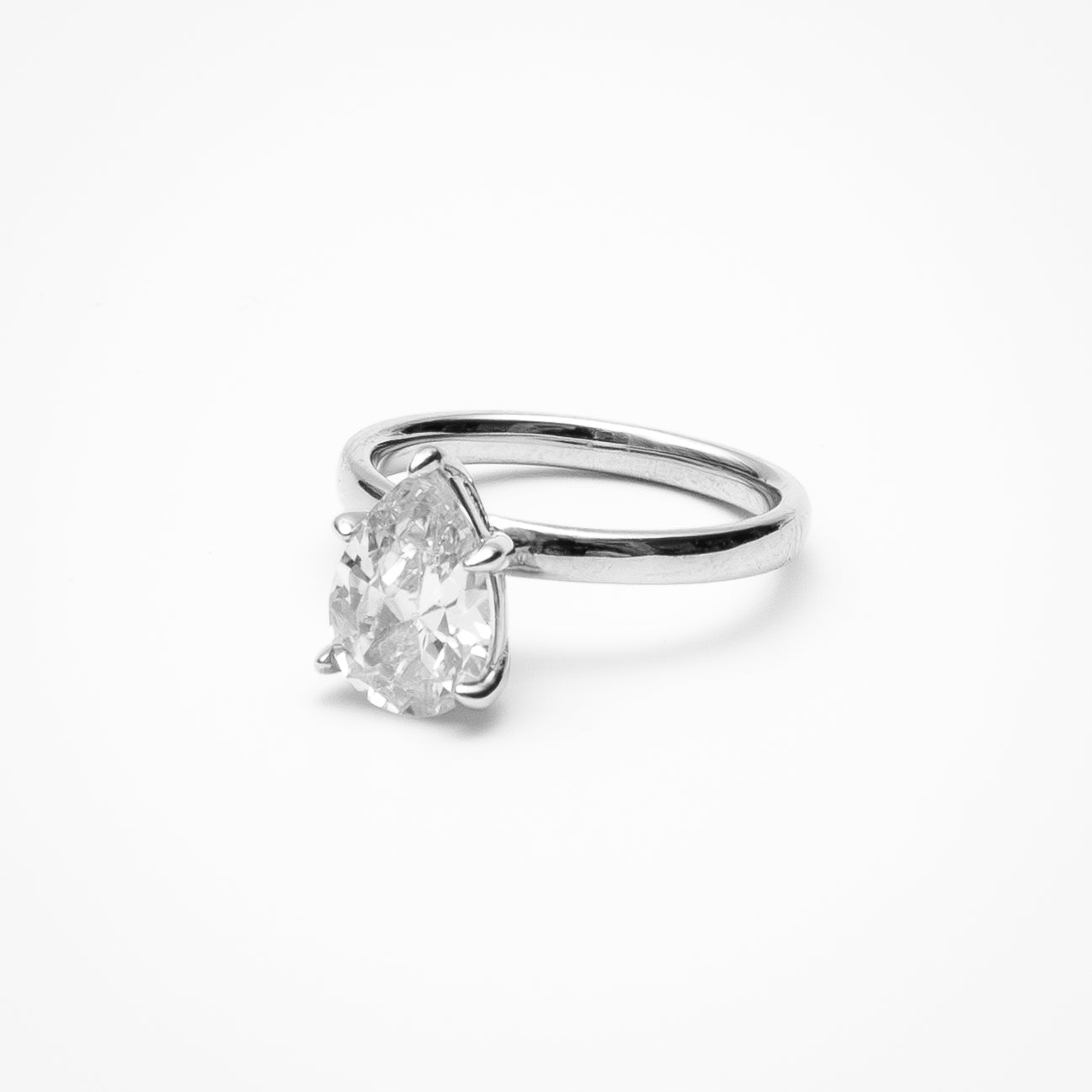 Pear cut cubic zirconia solitaire engagement ring in white gold setting on clean white background showcasing teardrop shape and elegant simplicity